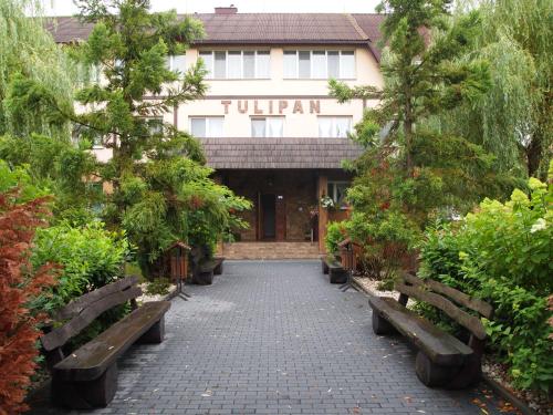 a building with benches in front of it at Tulipan Hotel Aquapark in Vyshkove