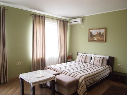 a bedroom with a bed with a table and a window at Tulipan Hotel Aquapark in Vyshkove