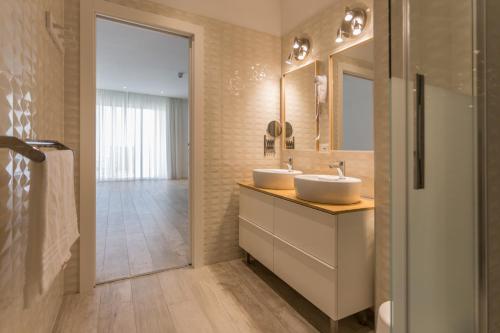 a bathroom with two sinks and a mirror at Hotel Speranza in Lido di Jesolo