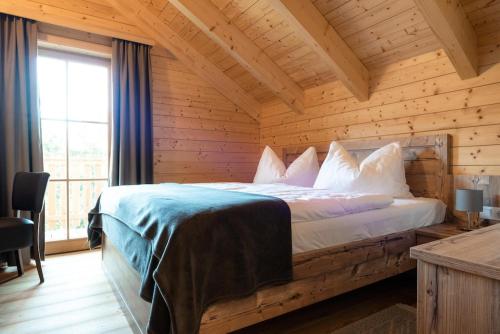 een slaapkamer met een bed in een houten kamer bij Holiday village Koralpe St- Stefan im Lavanttal - OKT07003-FYC in Elsenbrunn