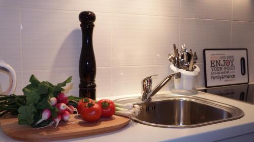 a kitchen counter with a sink and vegetables on a cutting board at Apartment Papalić Palace in Split