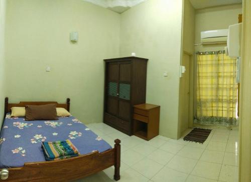 een slaapkamer met een bed en een dressoir bij Kayu Merbau Homestay in Seri Iskandar