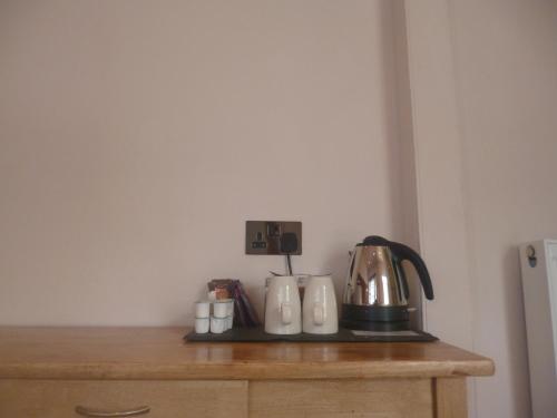 a tea kettle and cups on top of a dresser at Castle Hotel in Aberystwyth