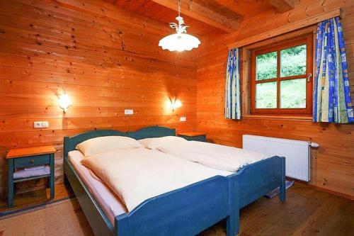 um quarto com uma cama azul num quarto de madeira em Holiday Village, Schlierbach em Schlierbach