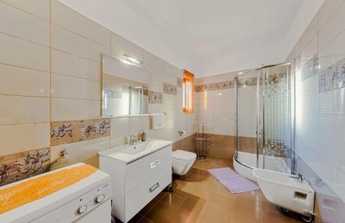 a bathroom with a sink and a toilet and a shower at Villa Klo - with pool in Valtura