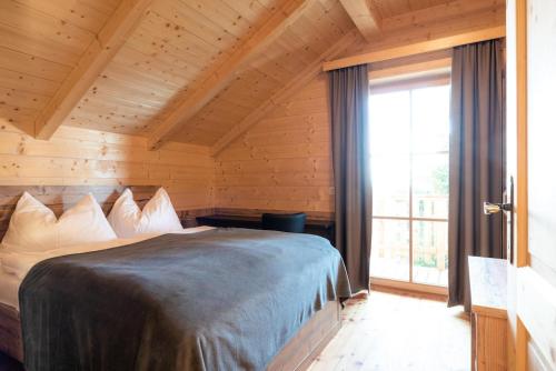 een slaapkamer met een bed en een groot raam bij Holiday village Koralpe St- Stefan im Lavanttal - OKT07003-FYD in Elsenbrunn