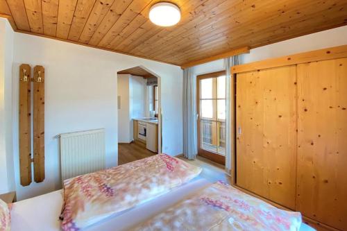 a bedroom with a bed and a wooden ceiling at Apartment in Filzmoos with a balcony in Filzmoos
