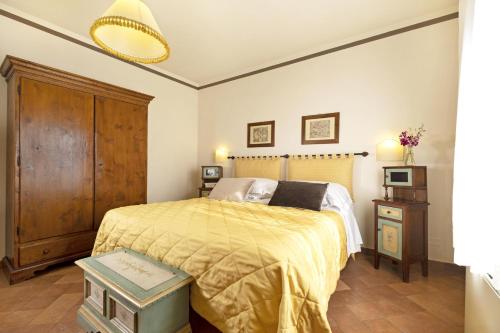 a bedroom with a bed with a yellow blanket at Borgo Grondaie in Siena