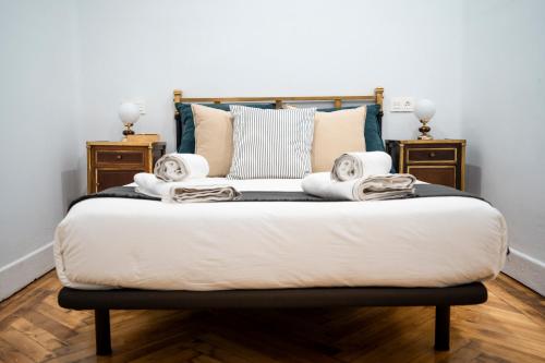 a bed with a white comforter and pillows on it at HiHome Hostel in Oviedo