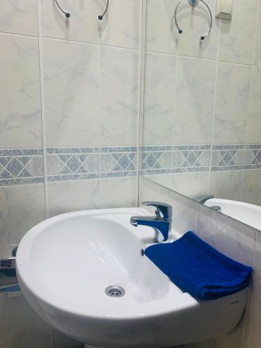a bathroom with a white sink and a blue towel at NB Hotel with Free Parking in Rīga