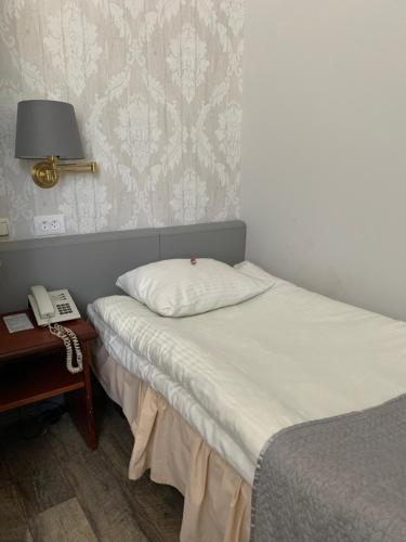 a bedroom with two beds and a phone next to a table at NB Hotel with Free Parking in Rīga