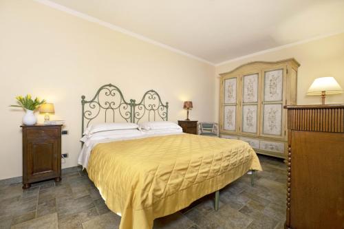 a bedroom with a large bed with a yellow bedspread at Borgo Grondaie in Siena