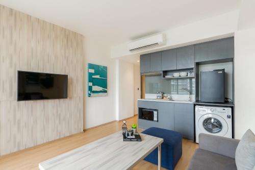 a living room with a table and a kitchen at Arden Hotel and Residence by At Mind in Pattaya Central