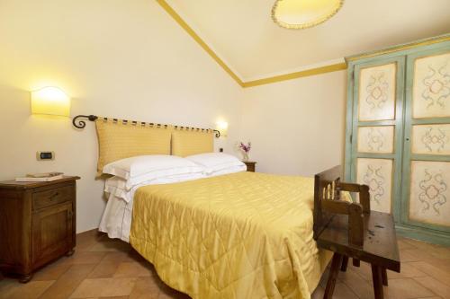 a bedroom with a bed with a yellow bedspread at Borgo Grondaie in Siena
