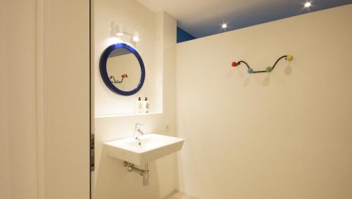 uma casa de banho com um lavatório e um espelho em Alte Metzg - Hostel em Appenzell