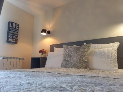 a bedroom with a bed with white sheets and pillows at La Maison de Fleurat in Domeyrot