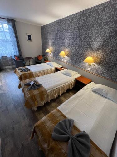 a room with four beds and a wall with wallpaper at NB Hotel with Free Parking in Rīga