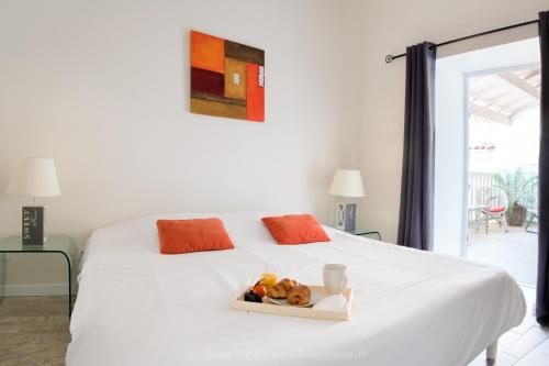 a white bed with a tray of food on it at La Virginie - Suite Parée'Ô in La Couarde-sur-Mer