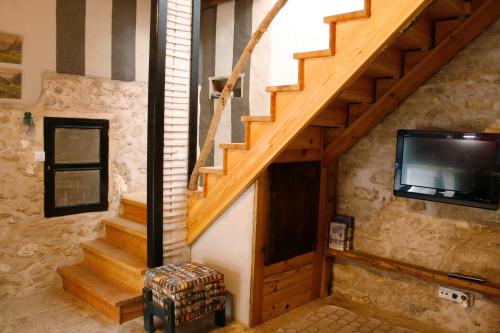a living room with a wooden staircase with a tv at Sonho do Poeta in Sintra
