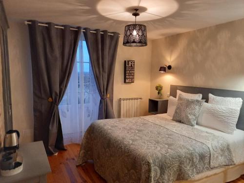 a bedroom with a bed and a window at La Maison de Fleurat in Domeyrot