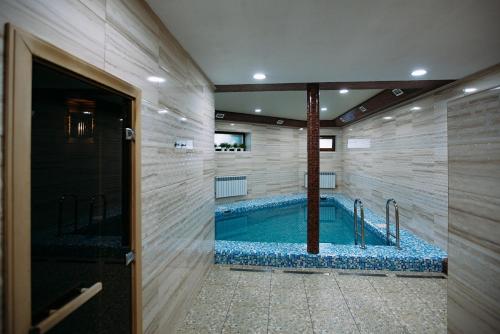 a bathroom with a large swimming pool in a room at Hotel in Ecopark Razdolye in Omsk