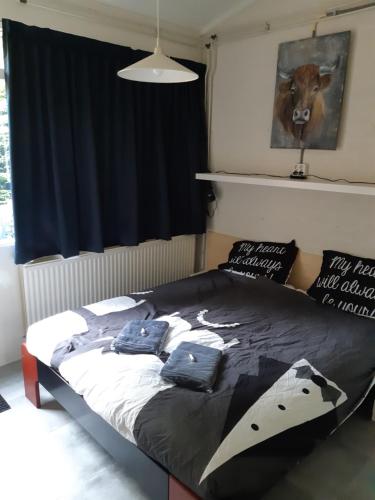 a bedroom with a bed with a cow on it at Vakantiehuis Veluwemeer House 40 in Biddinghuizen