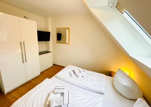 ein Schlafzimmer mit einem weißen Bett und einer Treppe in der Unterkunft Appartement christ-sylt in Westerland
