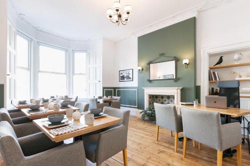 uma sala de estar com uma mesa e cadeiras e uma lareira em Castle Park Guest House em Edimburgo