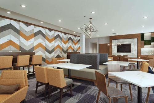 a restaurant with tables and chairs and a tv at La Quinta Inn & Suites by Wyndham Bardstown in Bardstown