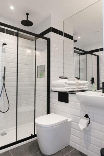 a bathroom with a shower and a toilet and a tub at Castle Park Guest House in Edinburgh