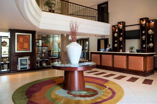 a lobby with a table with a vase on it at The RidgePoint Hotel in Witbank