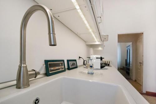 a white sink in a kitchen with a faucet at IMHOME - Porta Romana in Milan