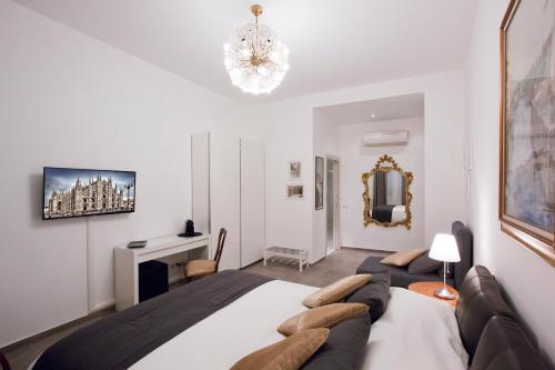 a bedroom with a large bed and a chandelier at IMHOME - Porta Romana in Milan