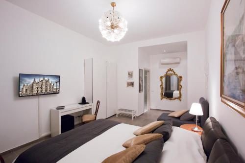 una camera da letto con un letto grande e un lampadario di IMHOME - Porta Romana a Milano