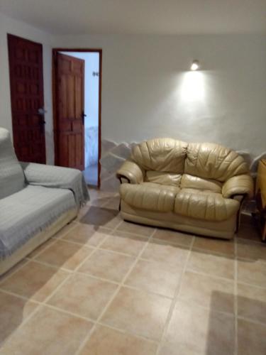 a living room with a couch and a bed at Almond Reef Casa Rural in Los Alias