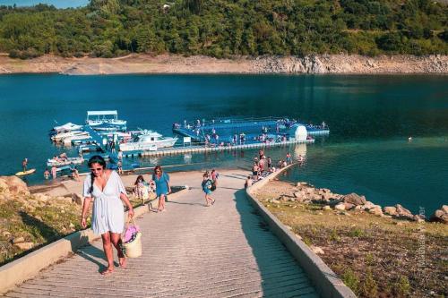 a woman walking down a boardwalk on a lake at Charming Garden Retreat in Pedrogao Grande in Pedrógão Grande