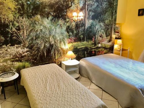 une chambre avec deux lits et un tableau au mur dans l'établissement appartquaisete et garage, à Sète