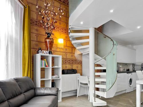 a living room with a staircase and a kitchen at Rare 1-Bed Church Converted Apartment in London in London