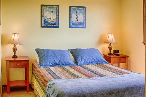 1 dormitorio con 1 cama y 2 mesitas de noche con lámparas en Ocean Surf Condos, en Ocean Shores