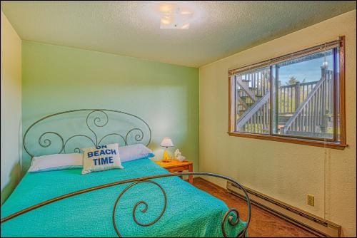 1 dormitorio con 1 cama y ventana con balcón en Ocean Surf Condos, en Ocean Shores