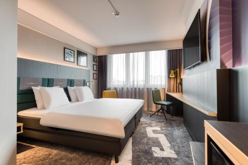 a hotel room with a bed and a tv at Mercure Neu-Isenburg in Neu Isenburg