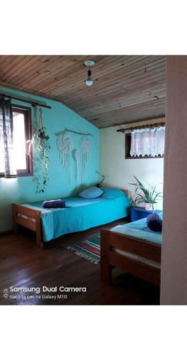 1 dormitorio con 2 camas y pared azul en Jardín de Naipí 3 en Puerto Iguazú