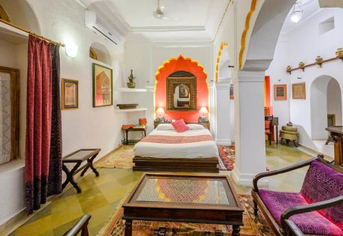 a bedroom with a bed and a couch in a room at Neemrana Fort-Palace in Neemrana