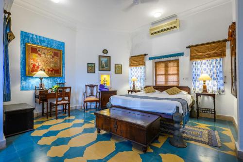 a bedroom with a king sized bed and a desk at Neemrana Fort-Palace in Neemrana
