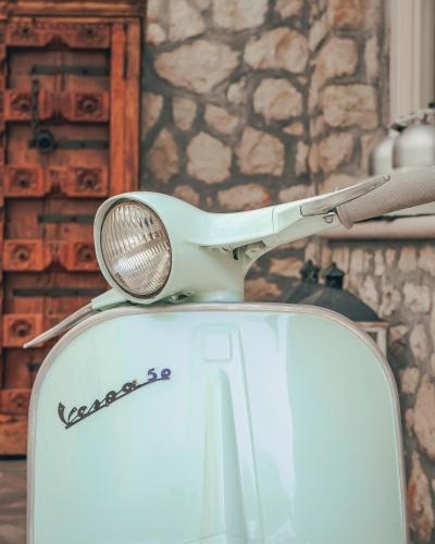a scooter parked in a room with a stone wall at Hotel Villa Florida & Suite Apartments in Gardone Riviera