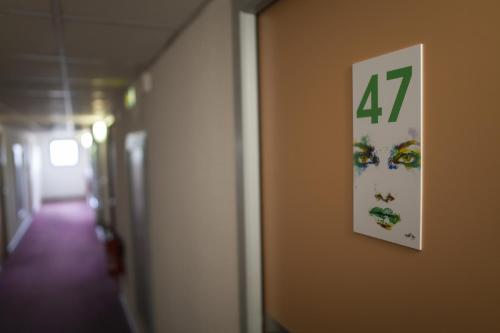 a clock on a wall with the number on it at Sure Hotel by Best Western Lille Tourcoing Ex Hotel Garden in Bondues