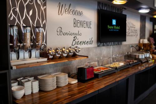 a buffet with plates and food on a counter at Sure Hotel by Best Western Lille Tourcoing Ex Hotel Garden in Bondues