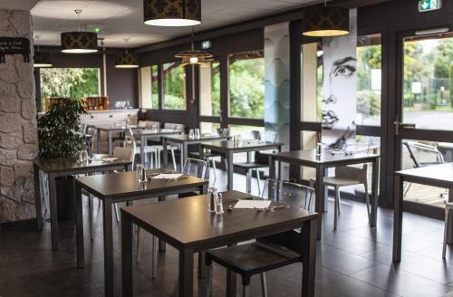 a dining room with tables and chairs and windows at Sure Hotel by Best Western Lille Tourcoing Ex Hotel Garden in Bondues