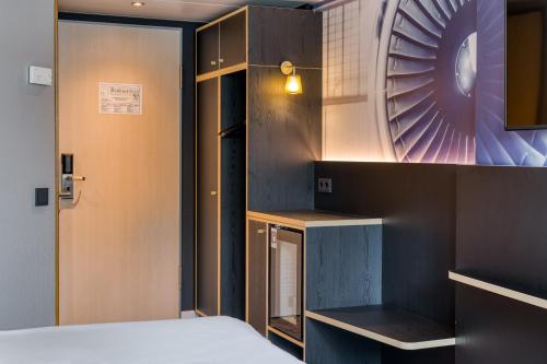 a bedroom with a bed and a wall with a fan at Mercure Neu-Isenburg in Neu Isenburg