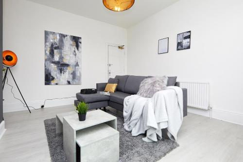 a living room with a couch and a table at Your Sheffield Stays - Spacious 5 Bedroom House in Sheffield